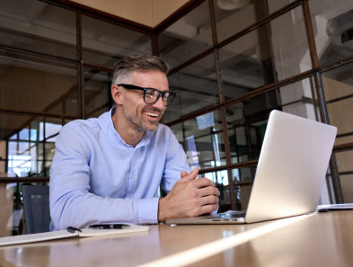 A person smiling while working at a laptop